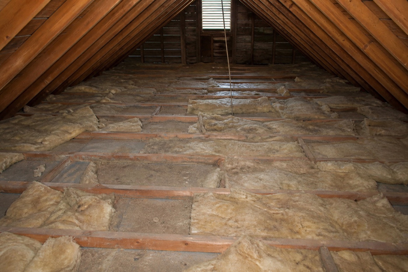 Thin patchy attic insulation with exposed joists